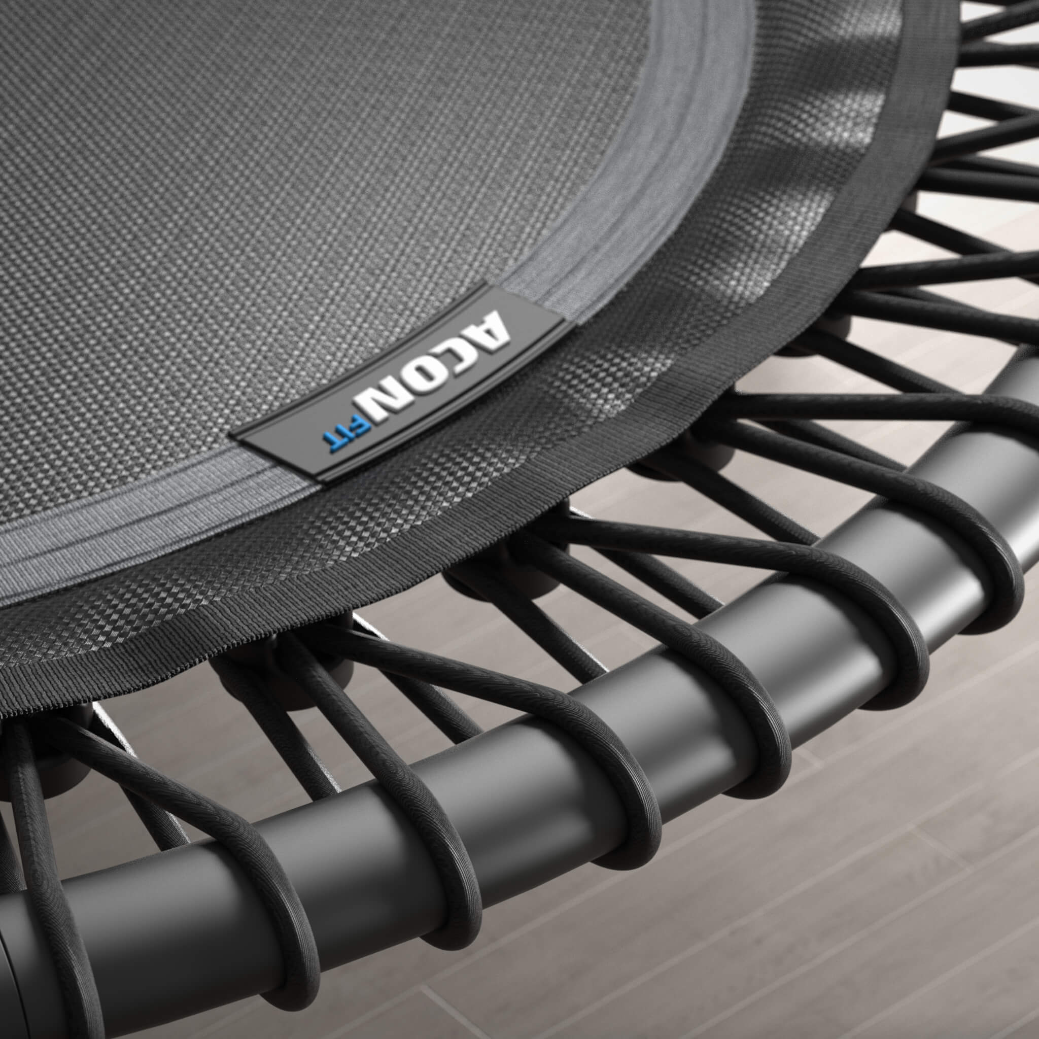 Close-up of the bungee cords of a black, round Acon FIT trampoline.