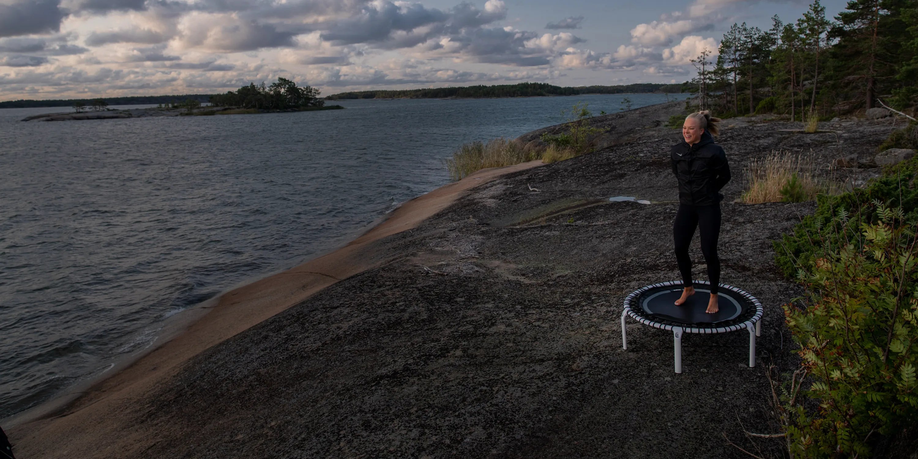 ACON Fit 1,12m Round Rebounder Fitness Trampoline with Balance Handlebar used for fitness by the seaside in Europe.