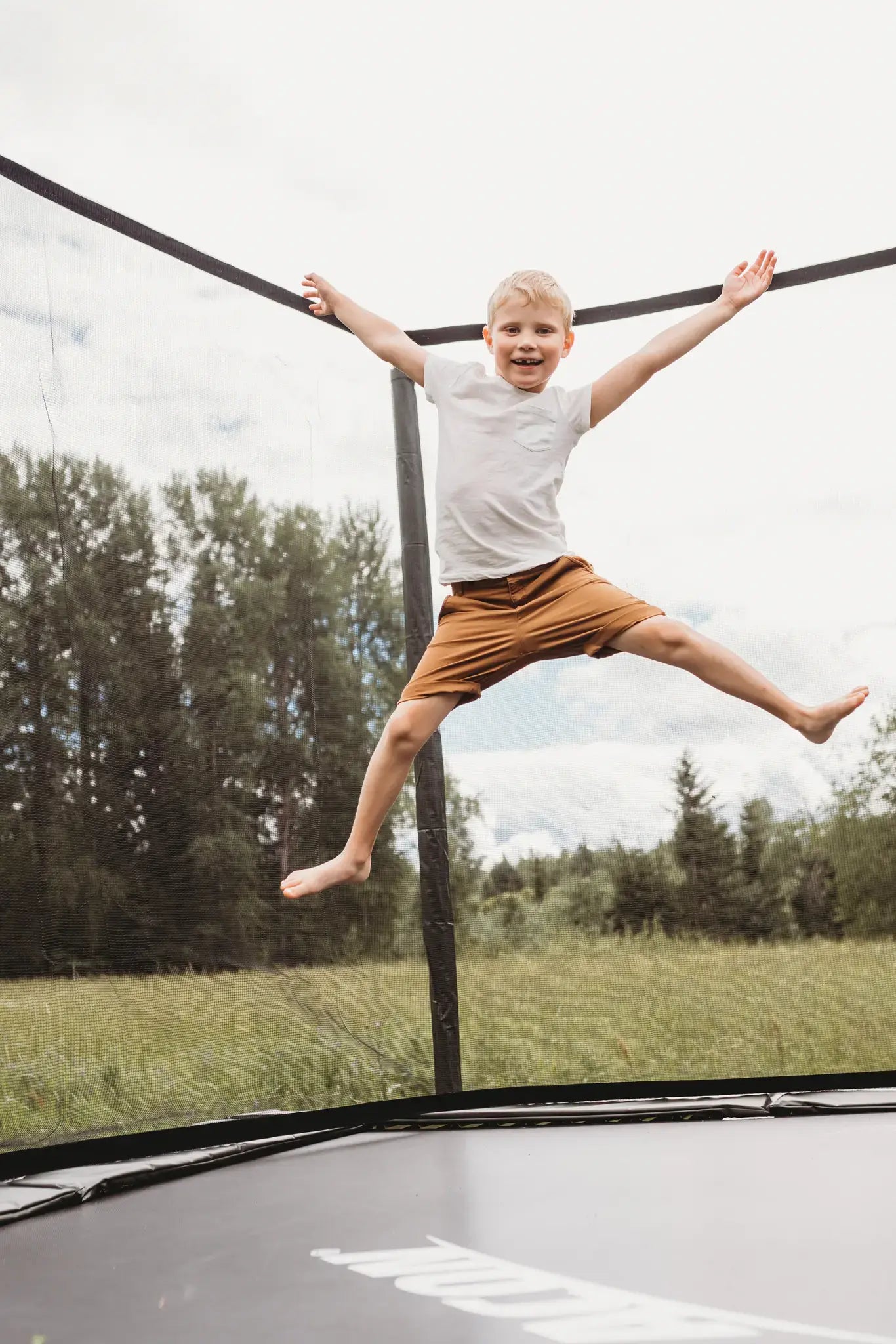 Young boy jumping high on a Acon trampoline. 