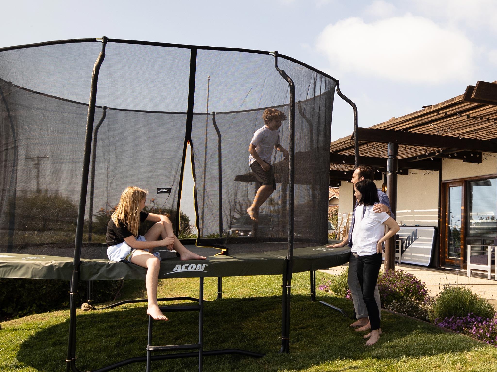 Family watching kid jumping on a trampoline