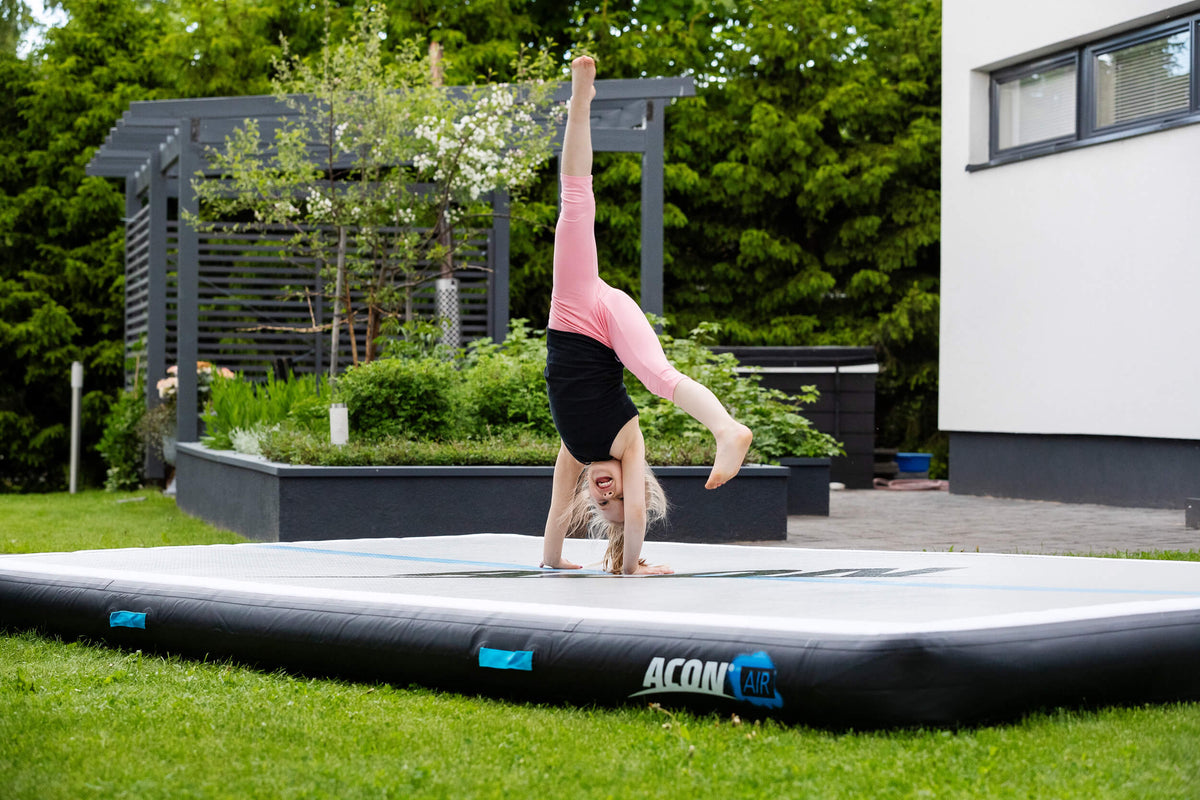 Girl doing cartwheel on Acon airtrack.