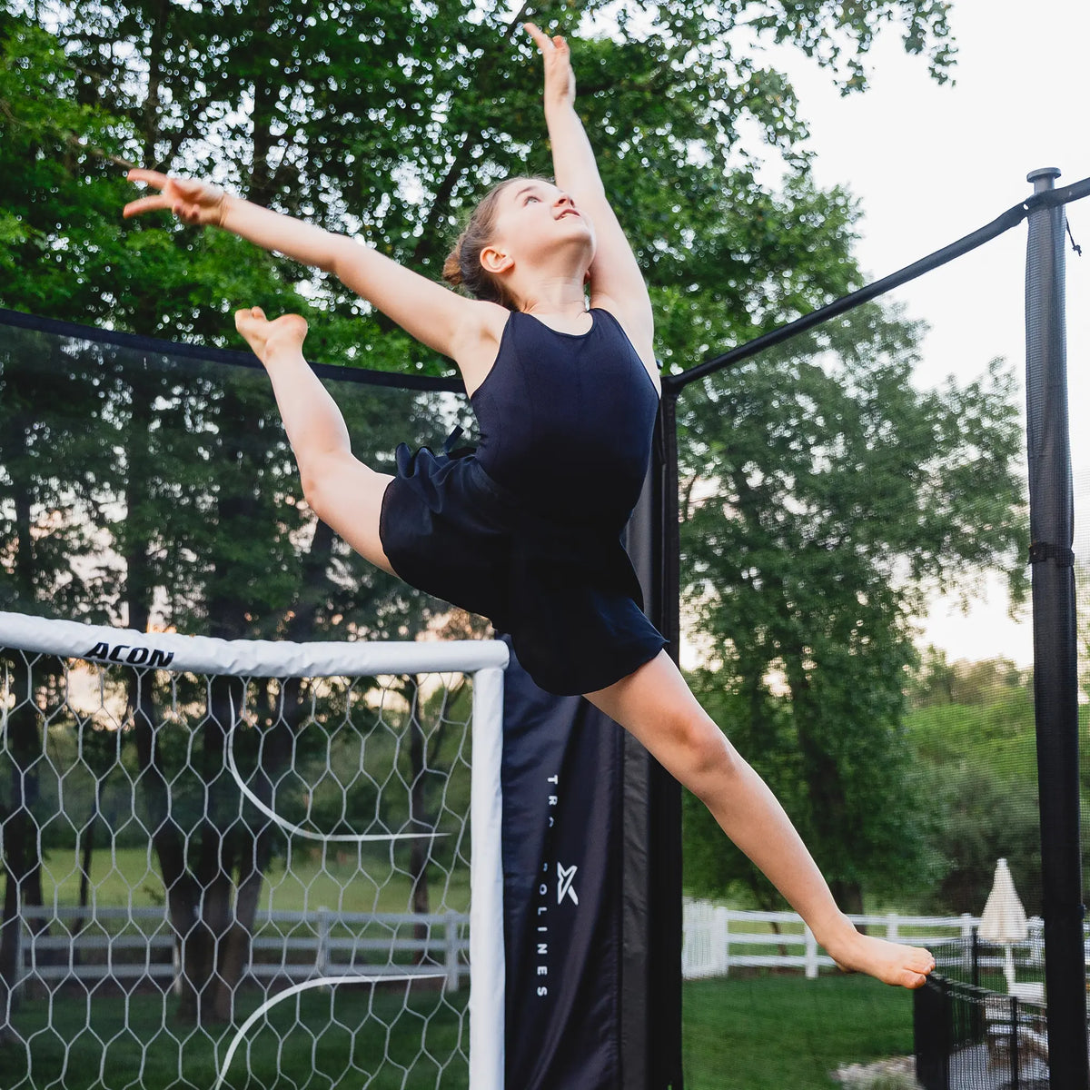 Girl doing a gymnastic jump on a Acon trampoline. 