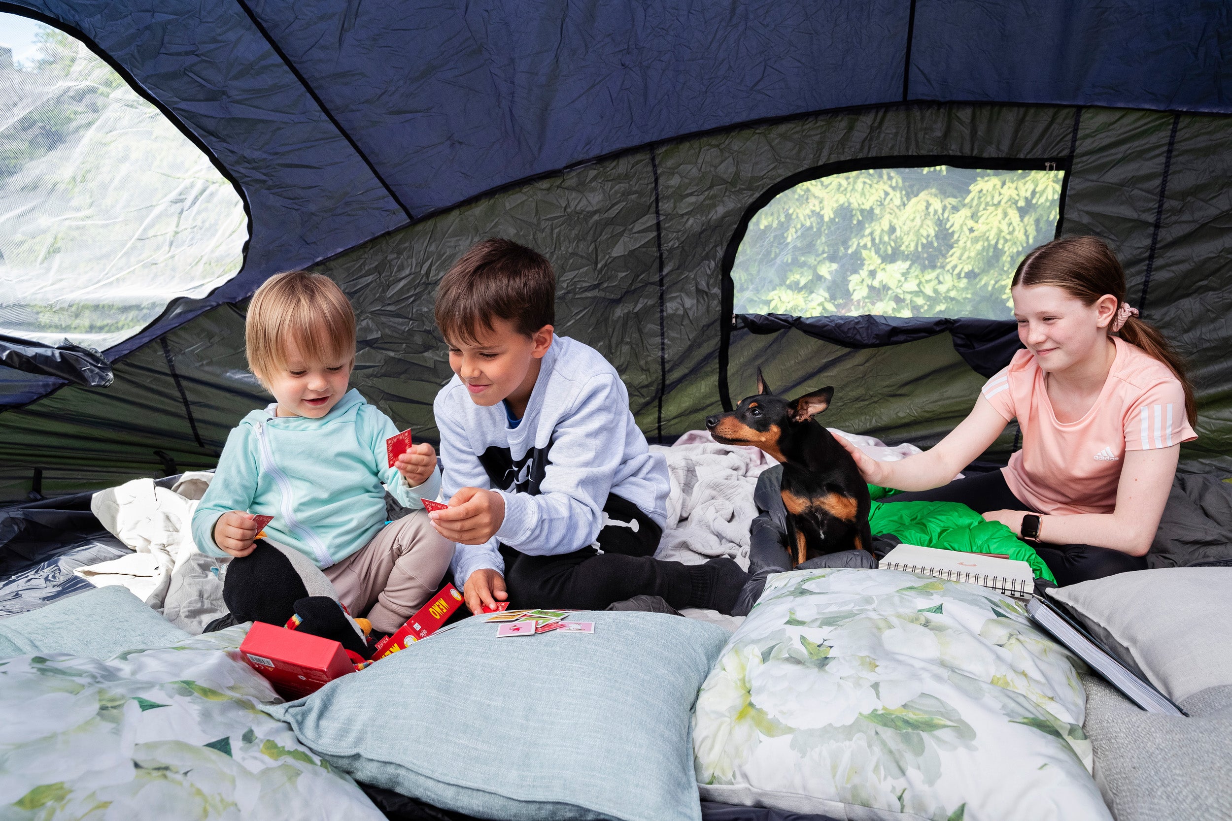 Kids reading and playing inside a trampoline tent