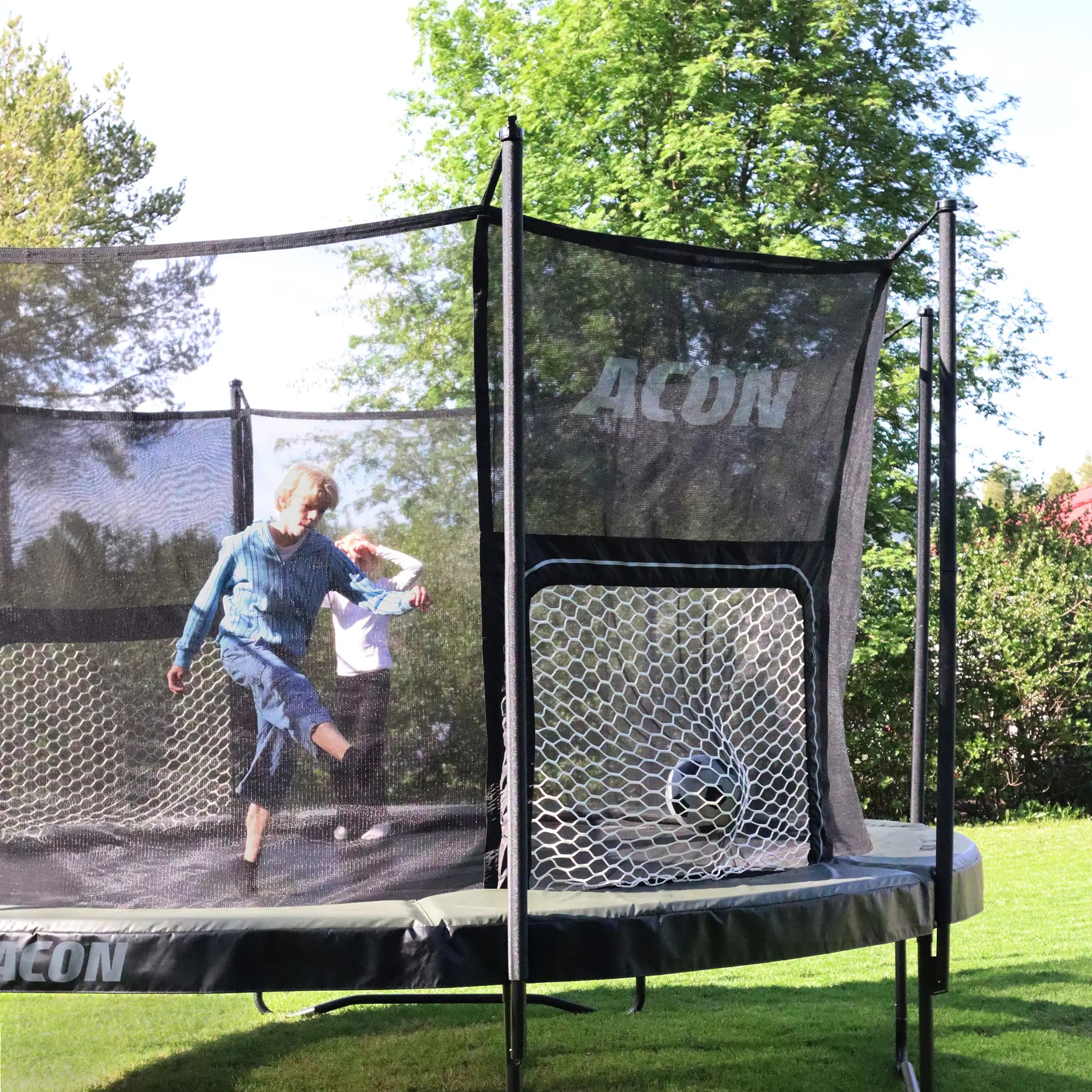 Children playing Football on an ACON Air Round trampoline on grass.