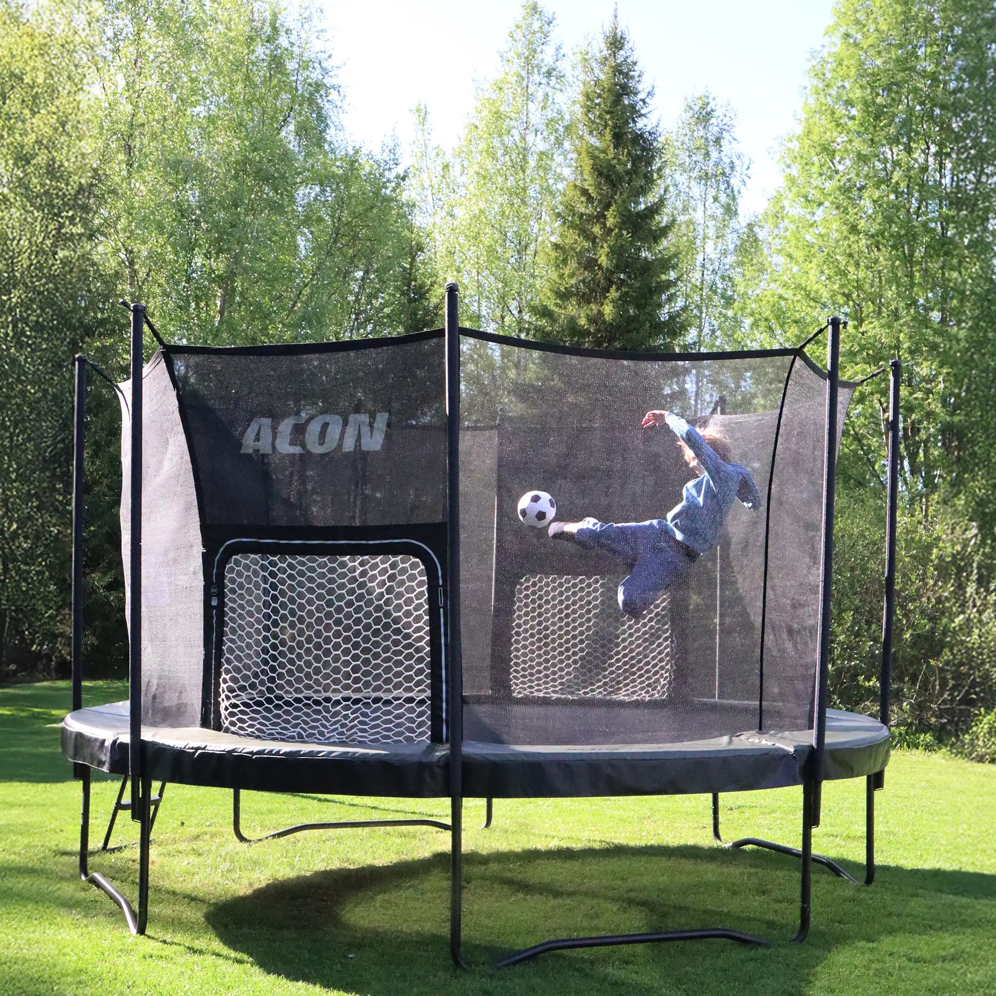 Child kicking a ball toward the ACON Air Football Goal Panel inside a trampoline.