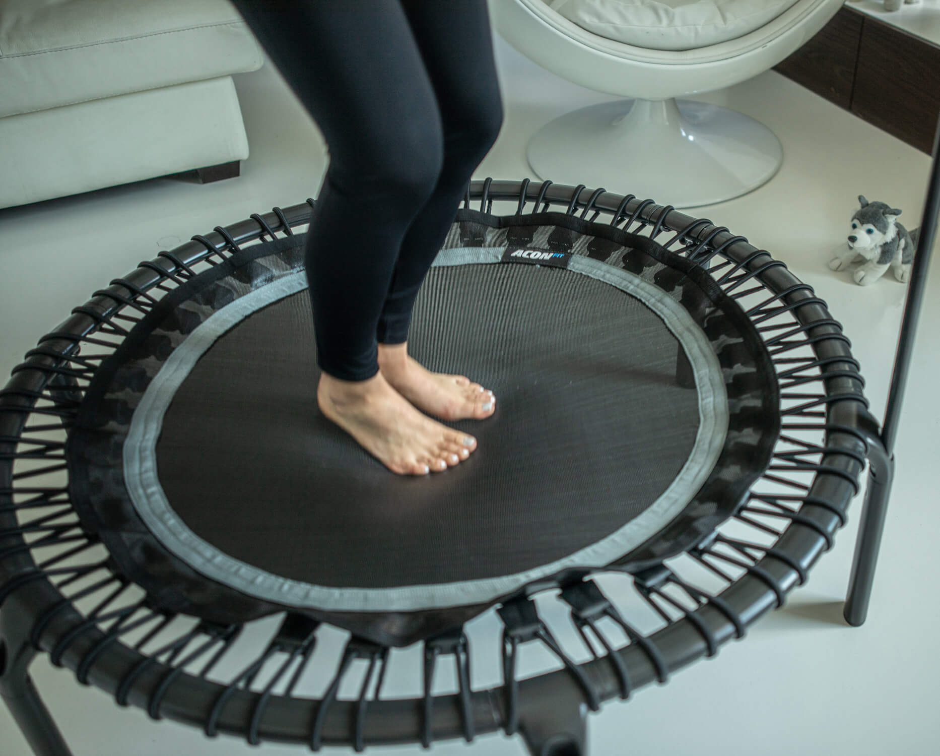 Knees to Chest Jump on a fitness rebounder - video still image.