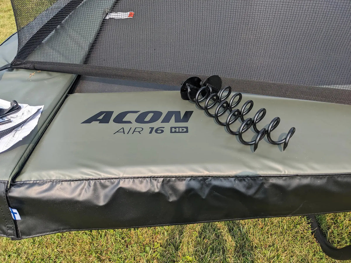 ACON Air 16 HD trampoline with ground anchors placed on the safety padding.