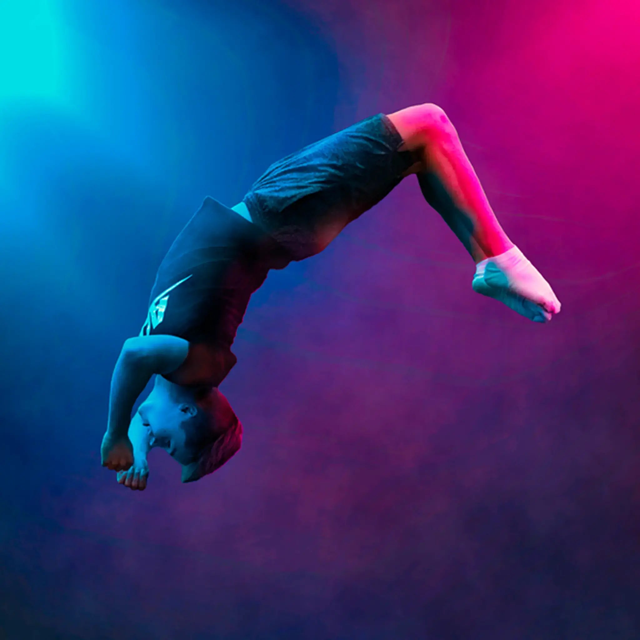Acon Brand Ambassador Markku Keski-Oja performing a backflip midair under dramatic blue and pink lighting.