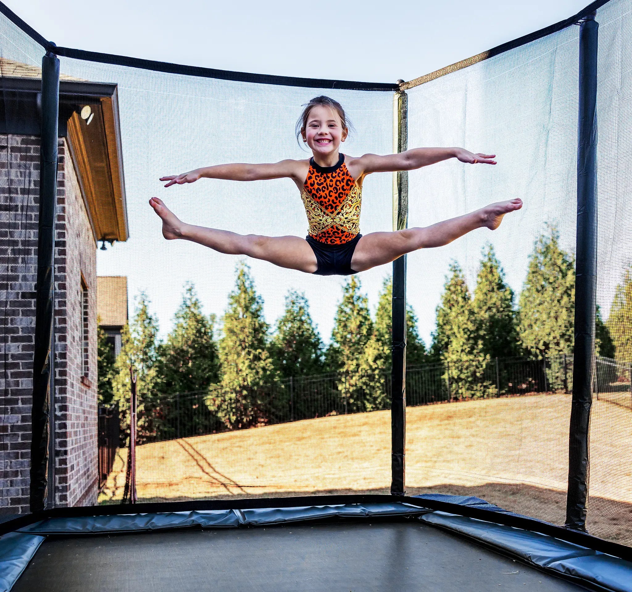 Young girl doing a professional gymnastic jump on a Acon trampoline. 