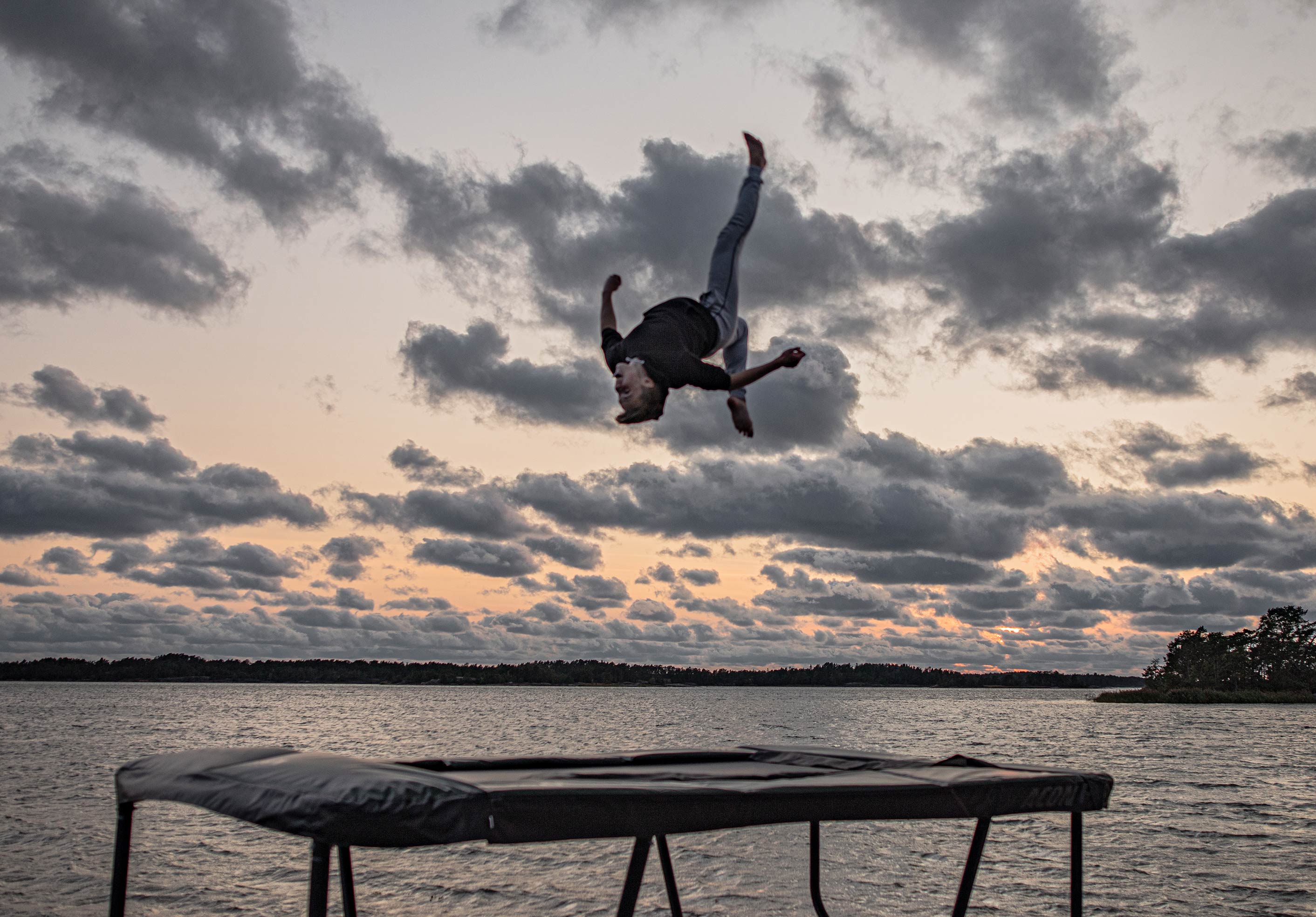 Skilled trampoline jump on the Acon 13HD trampoline, in an archipelago landscape