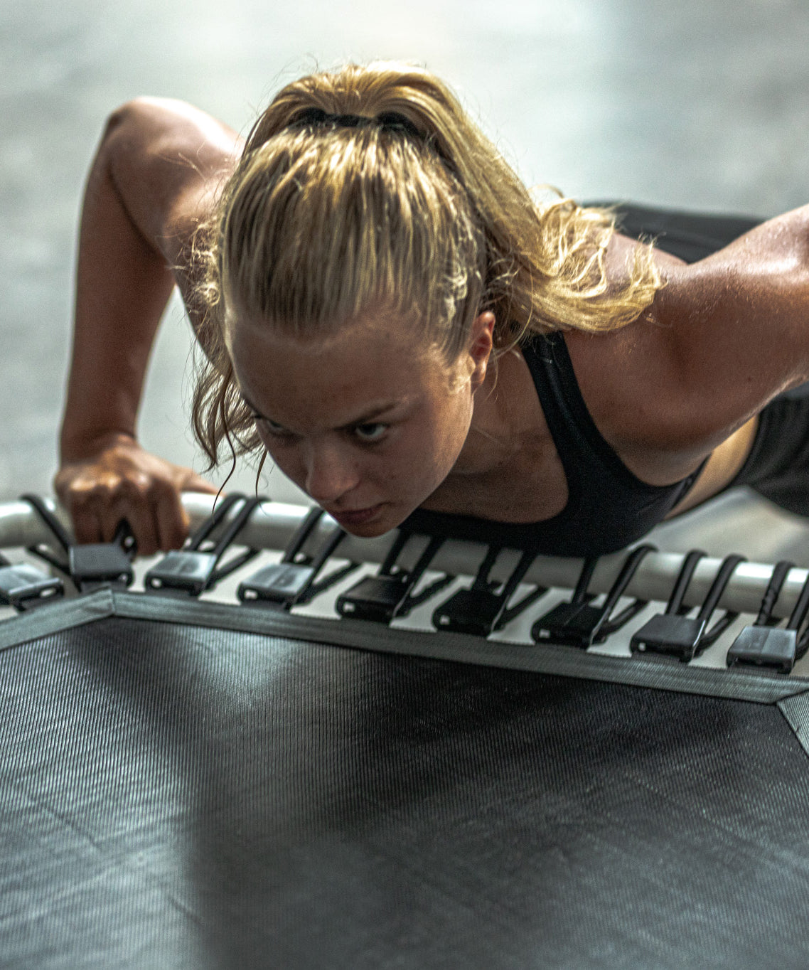 A woman doing front-leg push-ups on a fitness rebounder