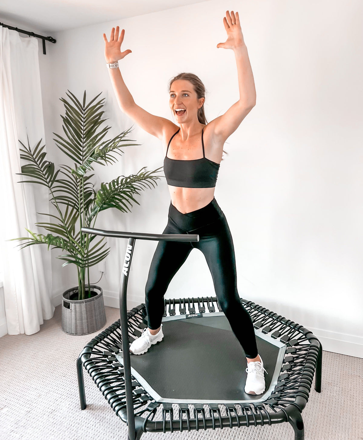 Trampoline fitness instructor Sydney doing X-jumps on an ACON fitness trampoline