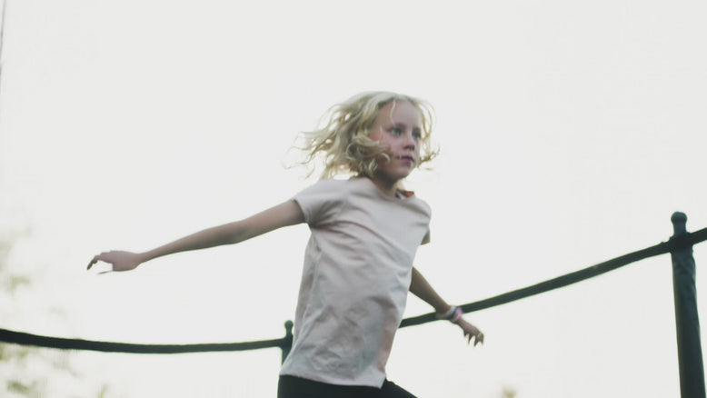 A girl jumping on an Acon trampoline with a focused look.