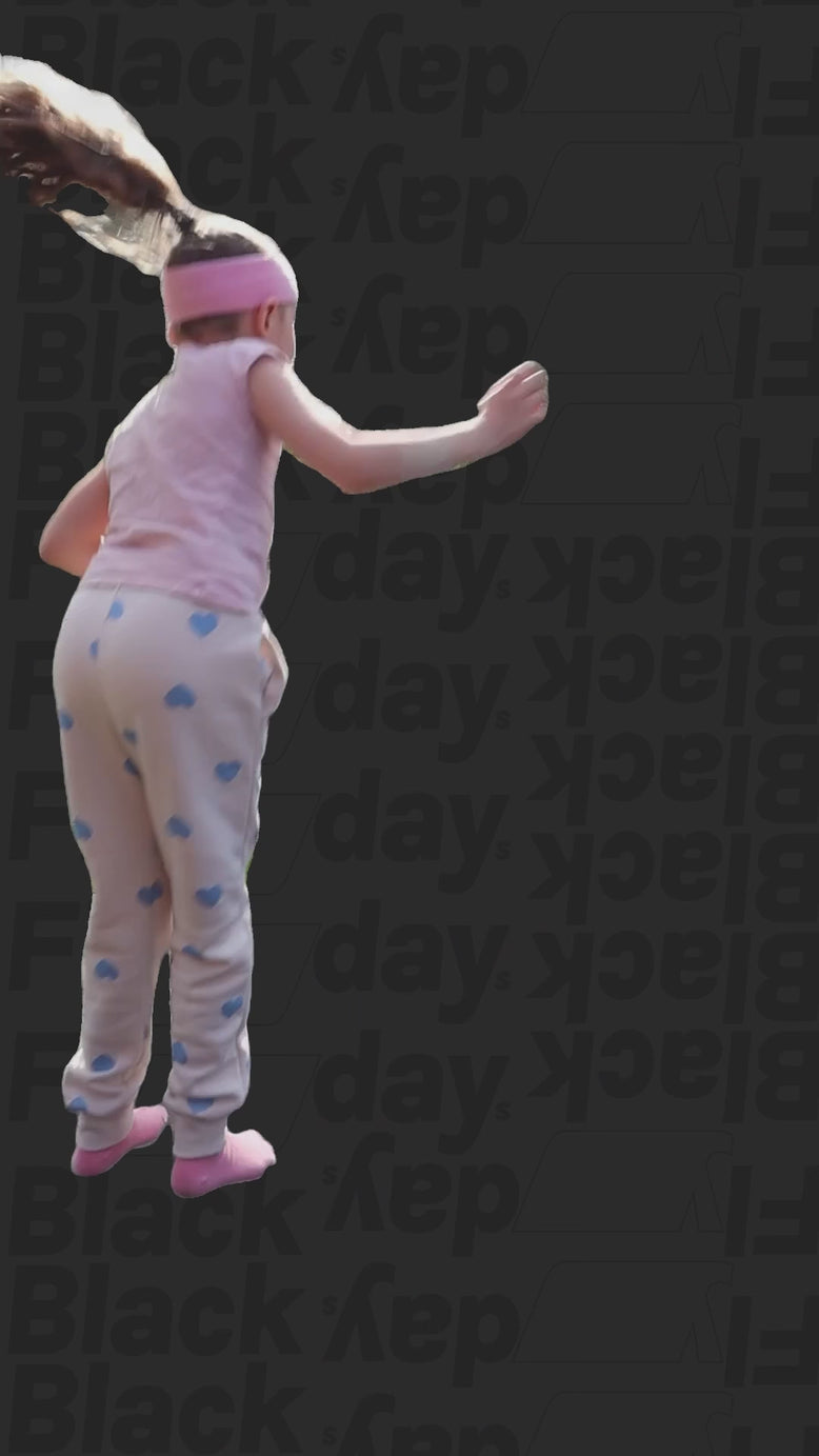 Video of a little girl wearing an Acon headband, bouncing on a black background with a Black Flydays pattern.