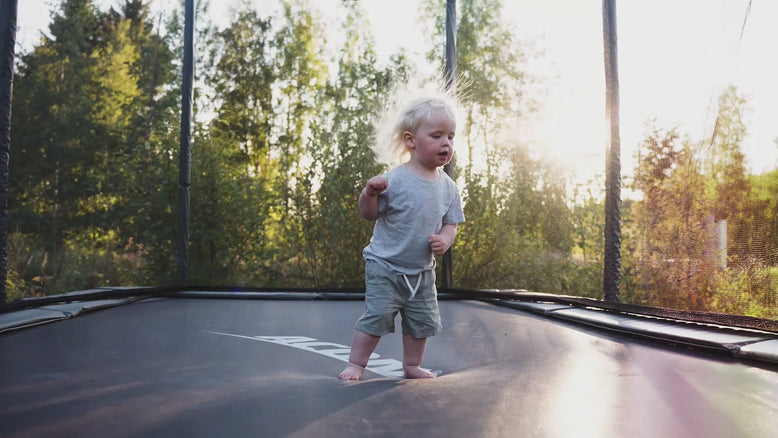 A video showing a father, daughter, and toddler taking turns jumping on an Acon trampoline.