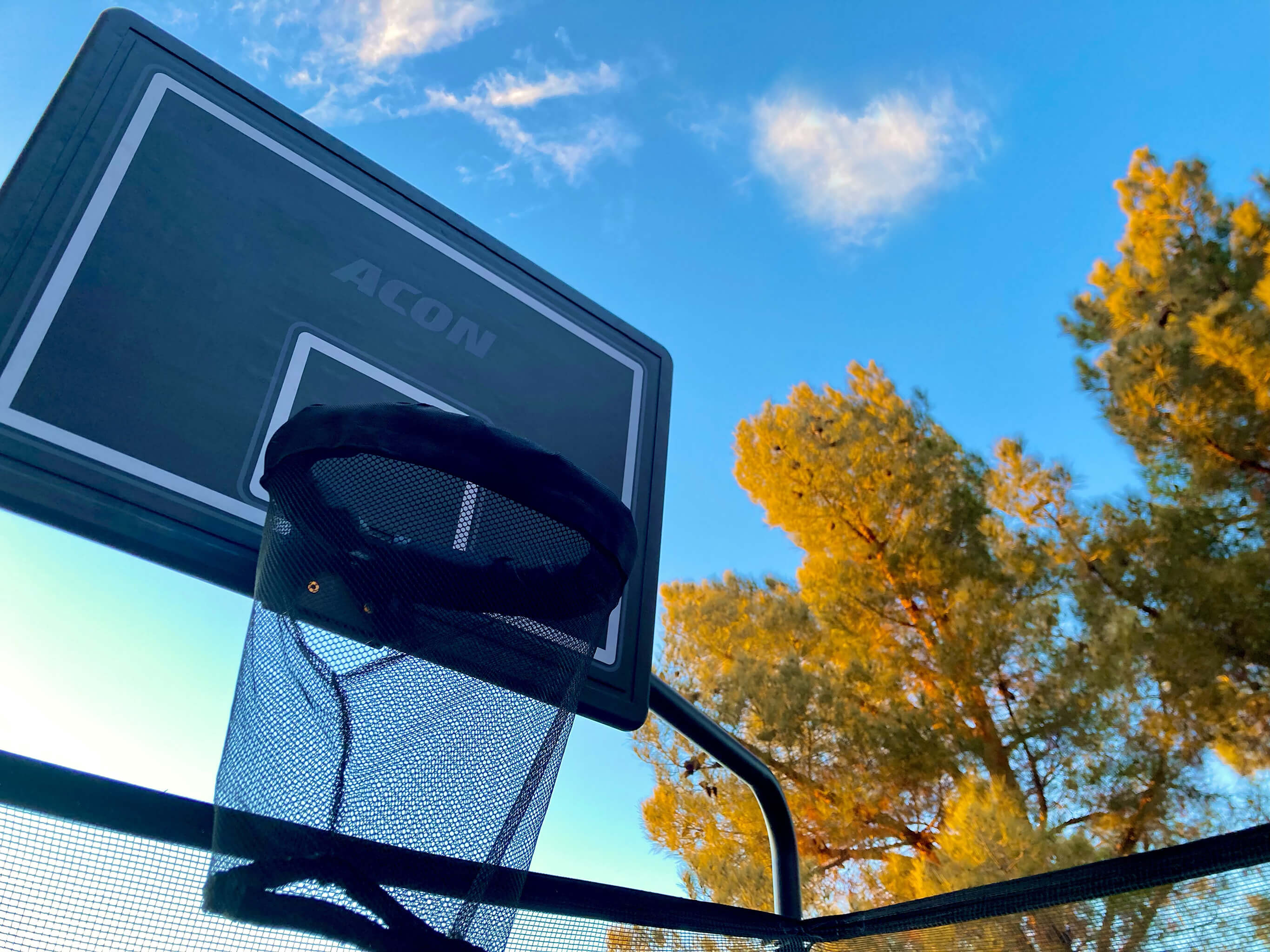 Trampoline basketball hoop and sky.