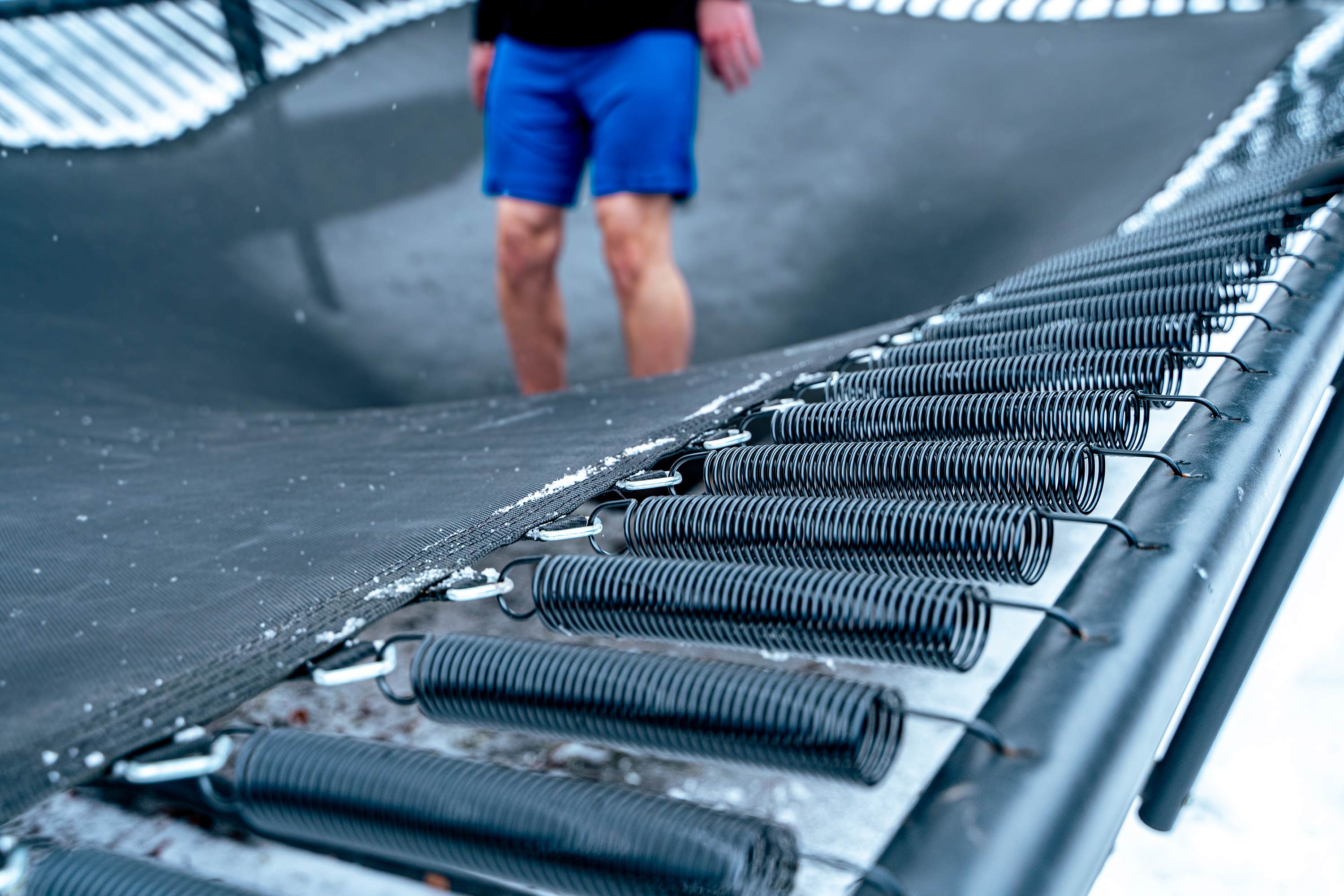 Trampoline jumper's feet when landed, mat and springs stretched