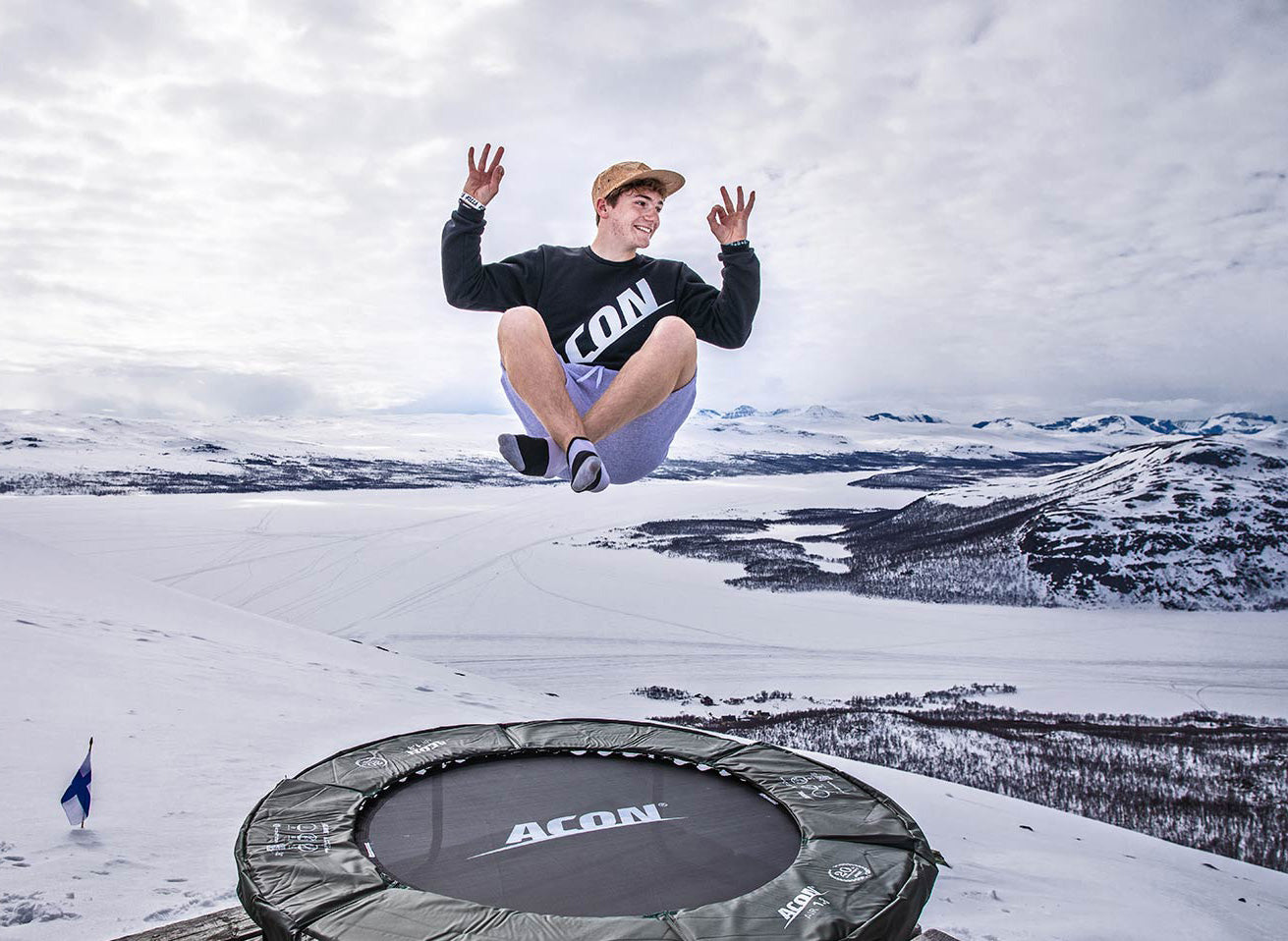 Happy yoga lotus pose trampoline jumper in a Lapland landscape