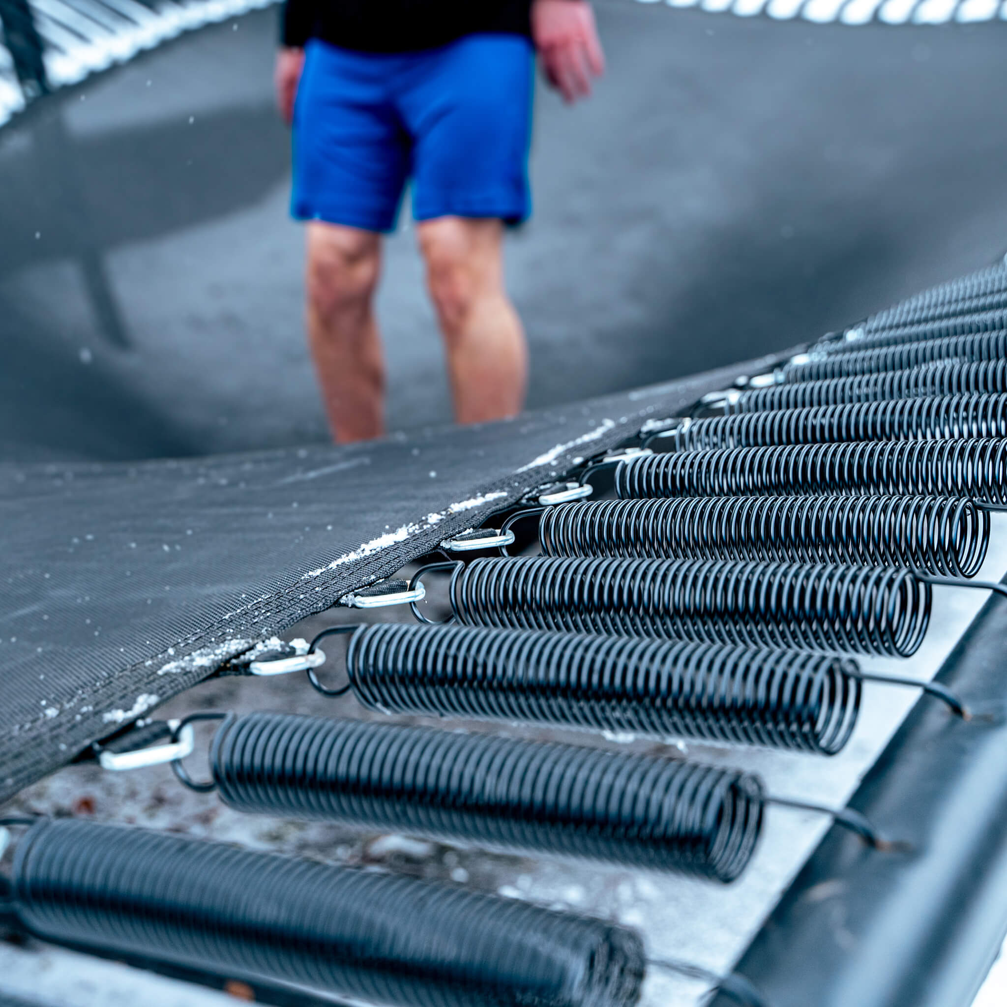 Trampoline jumper's feet on the mat, performance springs.