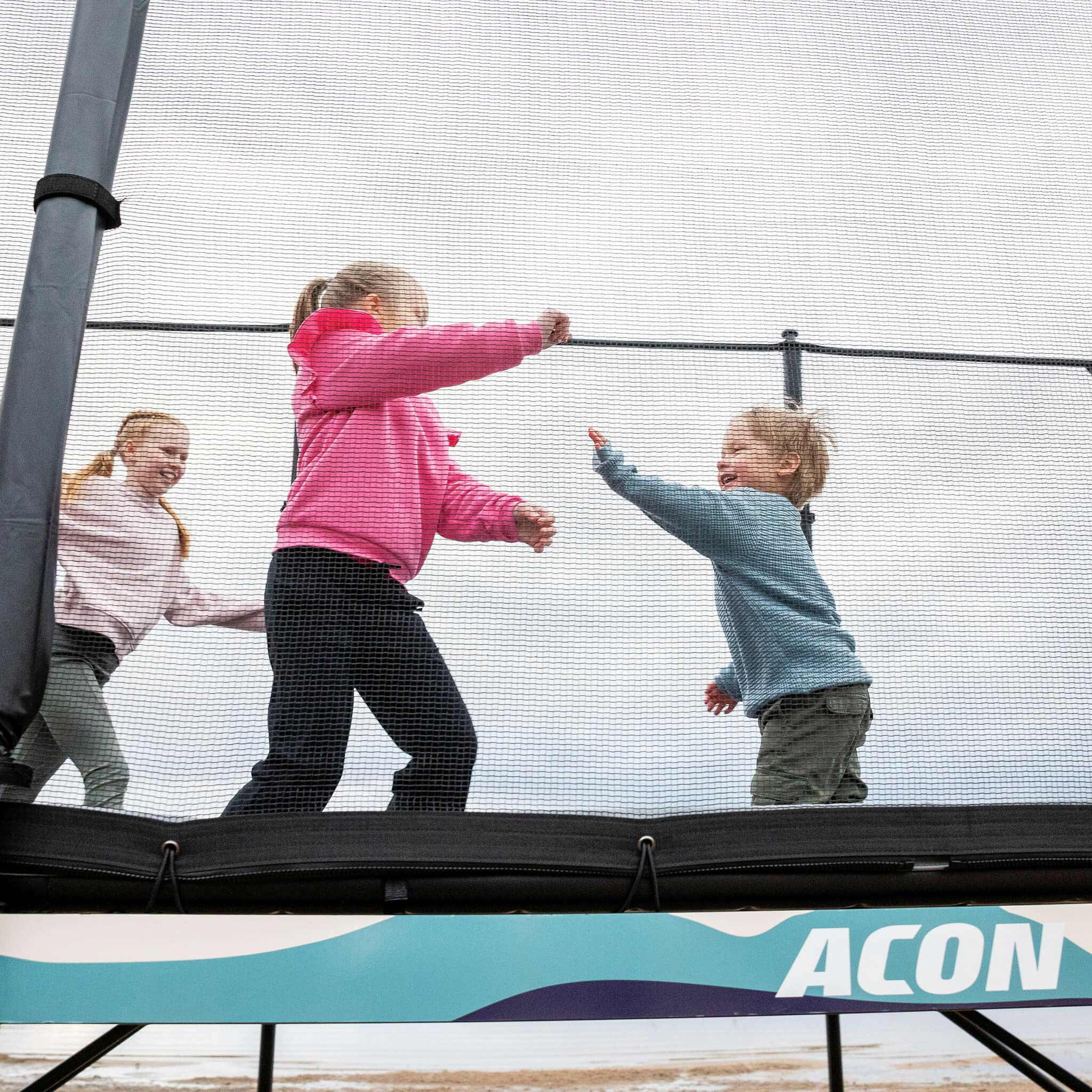 Three children play on the Acon X Trampoline.