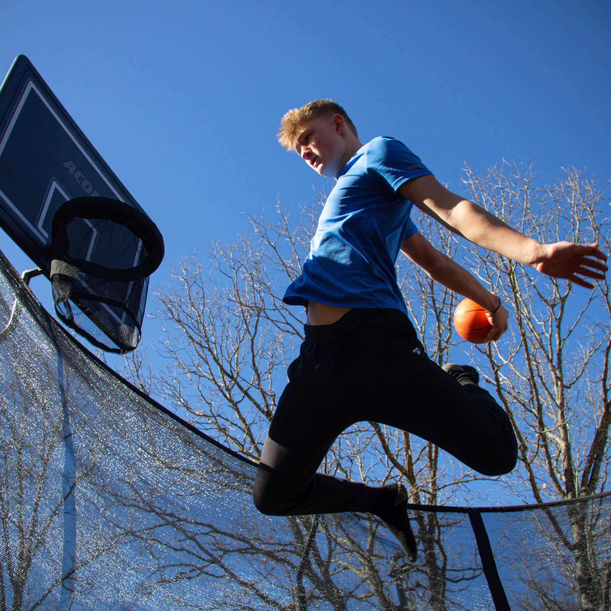 Basketball player on a round trampoline.